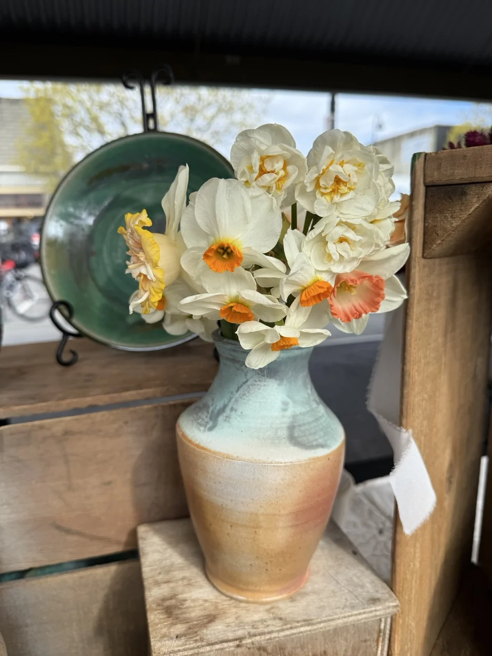 Soda fired vase with mint top and tan bottom, holding white flowers