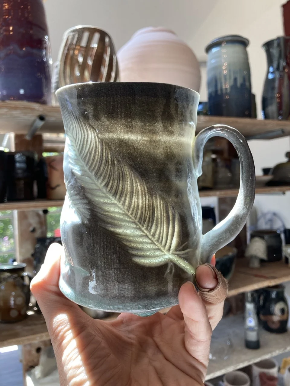 Transluscent mug with a feather carving
