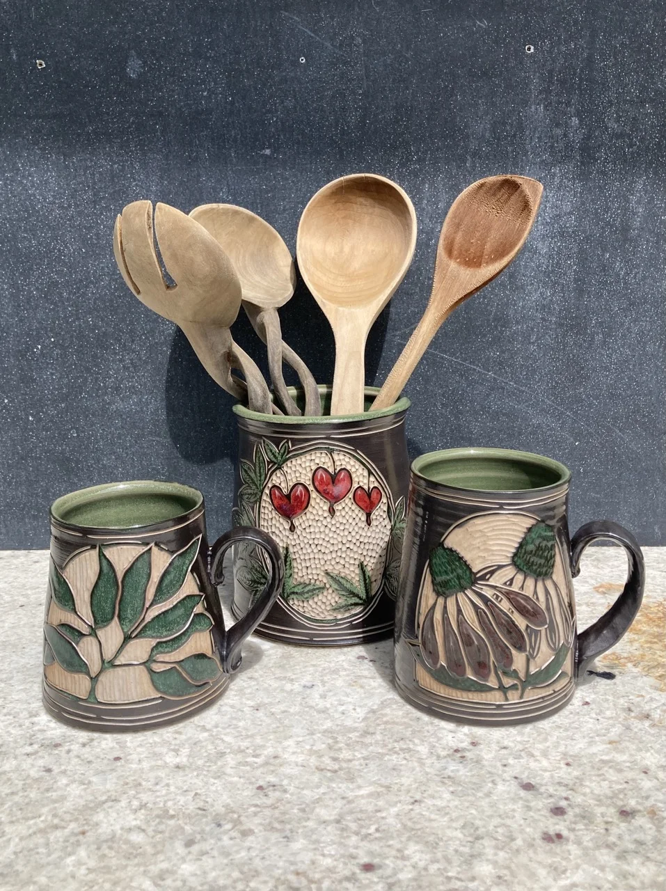 Three painted and carved black and white mugs