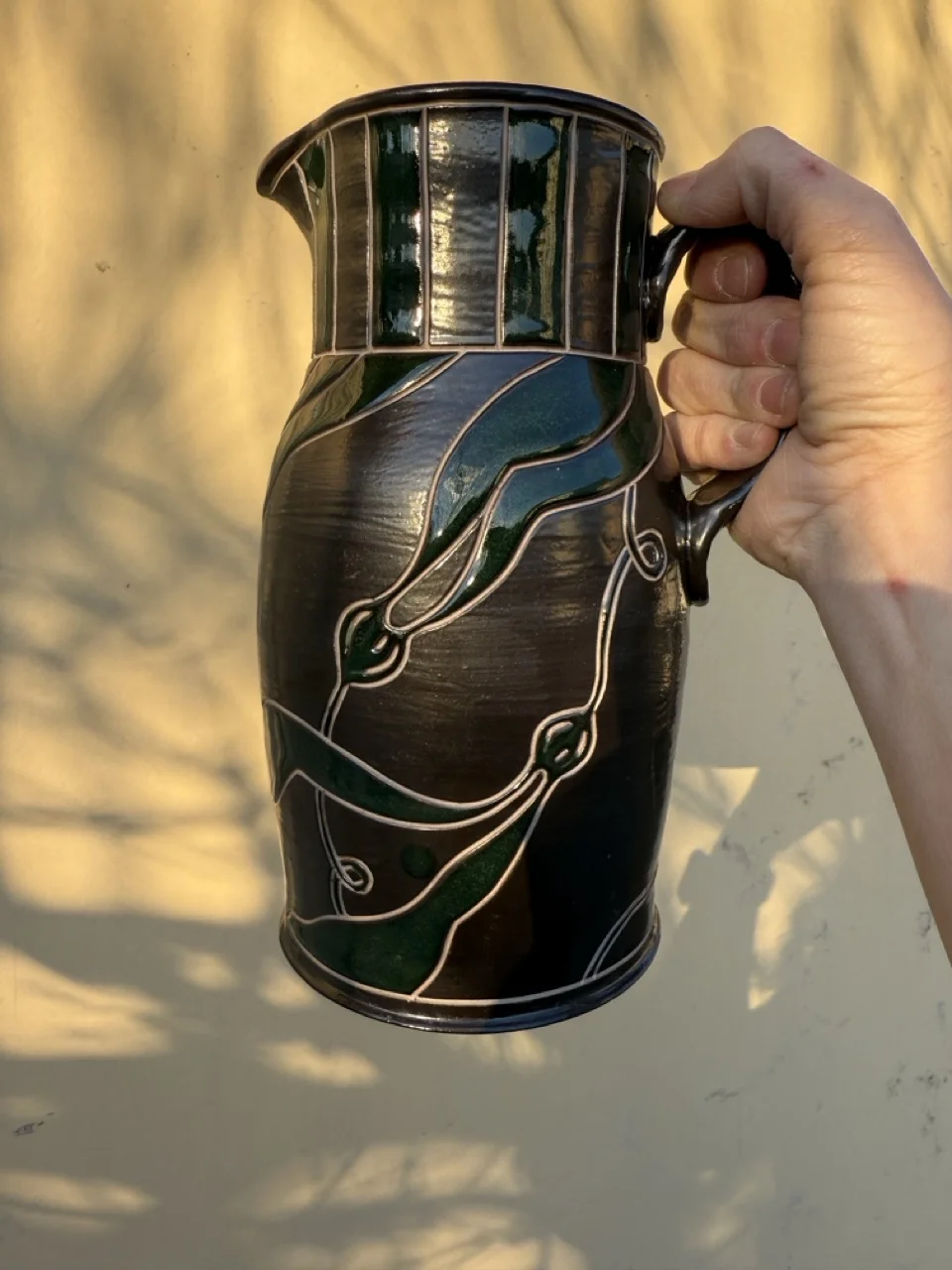 Black pitcher with dark green seaweed decoration